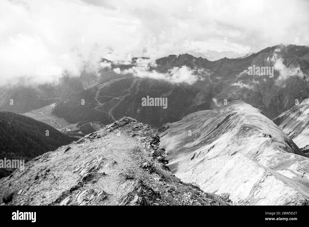 Wolkiger Himmel mit Blick auf eine Bergkette in Südtirol Stockfoto