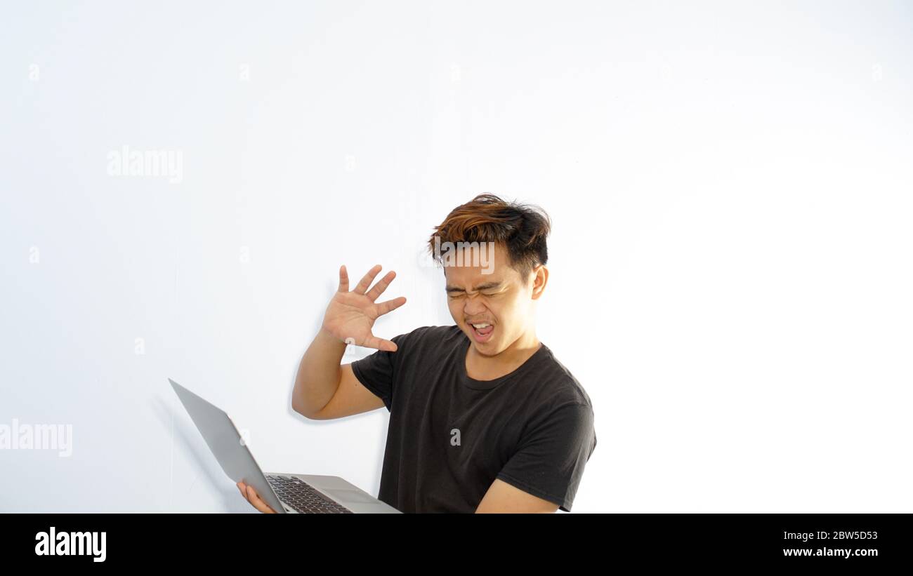Schockiert Casual Mann mit geschlossenen Augen ist gegen unzensierte Internet-Inhalte / überwältigt asiatischen Mann schließen seine Augen und wandte sich weg von der Laptop-Scre Stockfoto