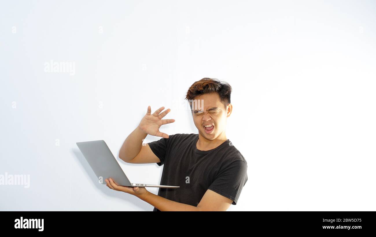 Schockiert Casual Mann mit geschlossenen Augen ist gegen unzensierte Internet-Inhalte / überwältigt asiatischen Mann schließen seine Augen und wandte sich weg von der Laptop-Scre Stockfoto