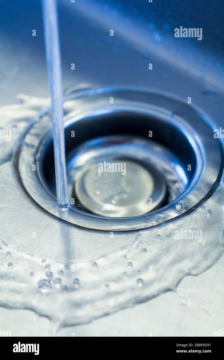 Fließendes Wasser, das das Loch des Spülbeckens herunterläuft. Stockfoto