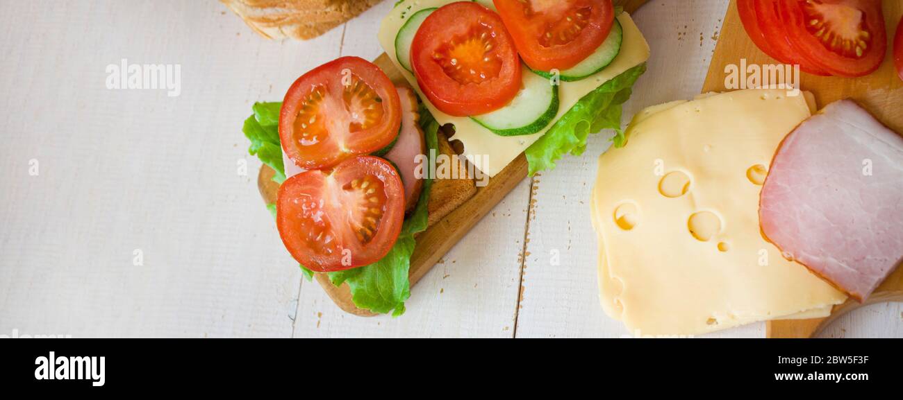 Toast mit Käse und Schinken. Tomaten und Grüns. Gesundes Essen Konzept. Banner. Blick von oben. Copyspace. Stockfoto