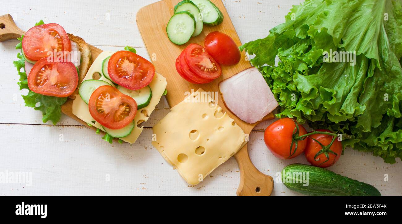 Toast mit Käse und Schinken. Tomaten und Grüns. Gesundes Essen Konzept. Toastkonzept. Banner. Blick von oben. Copyspace. Stockfoto