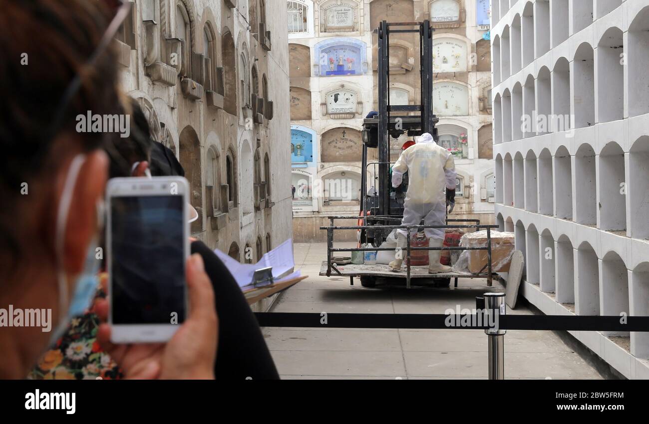 Lima, Peru. Mai 2020. Eine Frau mit Mundschutz filmt mit ihrem Mobiltelefon die Beerdigung eines Covid 19-Opfers auf dem El Angel Friedhof. Das südamerikanische Land hat 141,779 Covid-19-infizierte und 4,099 Todesfälle durch Coronavirus bestätigt. Kredit: Cesar Lanfranco/dpa/Alamy Live News Stockfoto