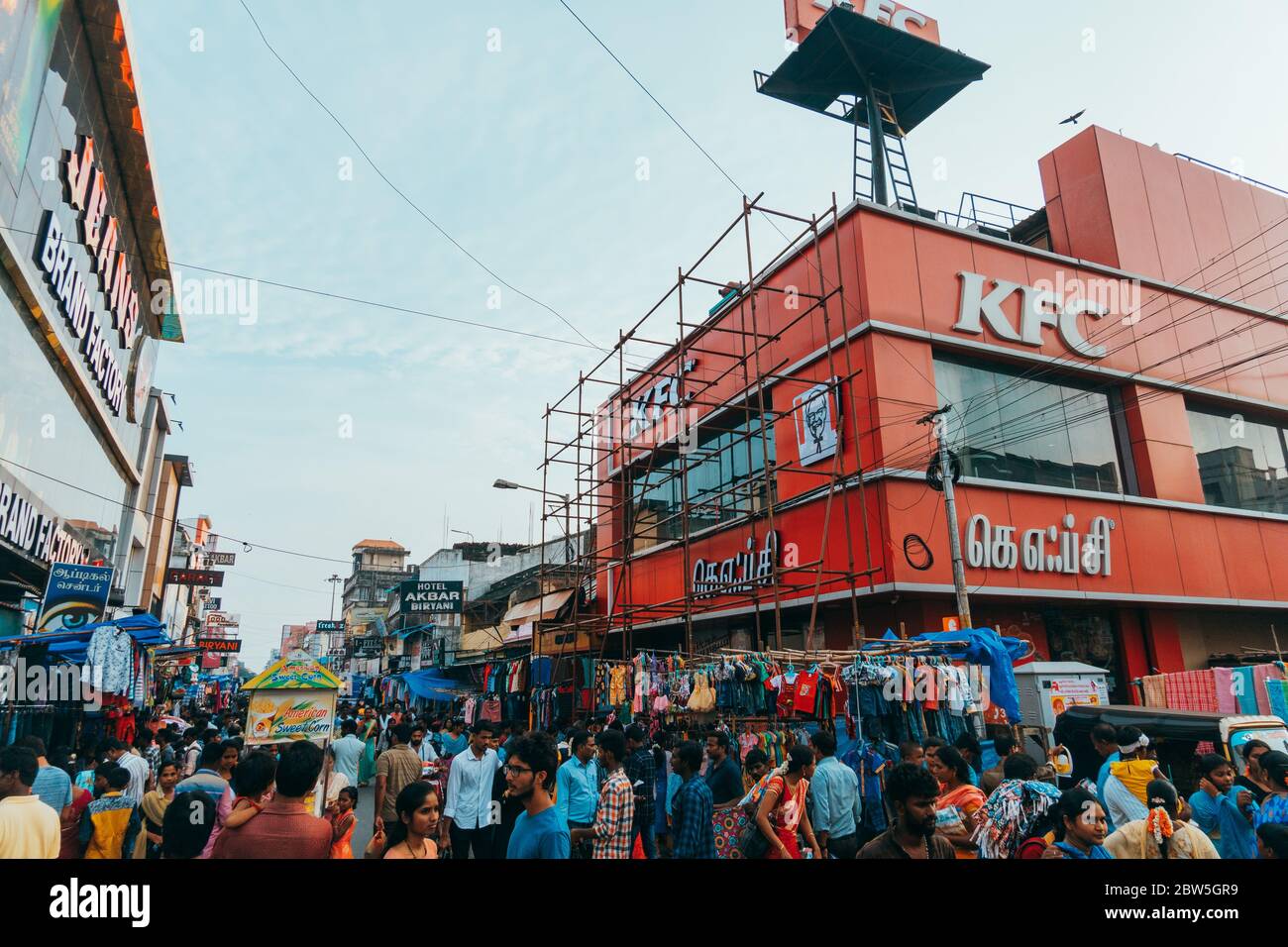 Ein KFC Kentucky Fried Chicken Restaurant an der Ecke einer vollgepackten Innenstadtstraße an einem Sonntagabend in Pondicherry, Indien Stockfoto