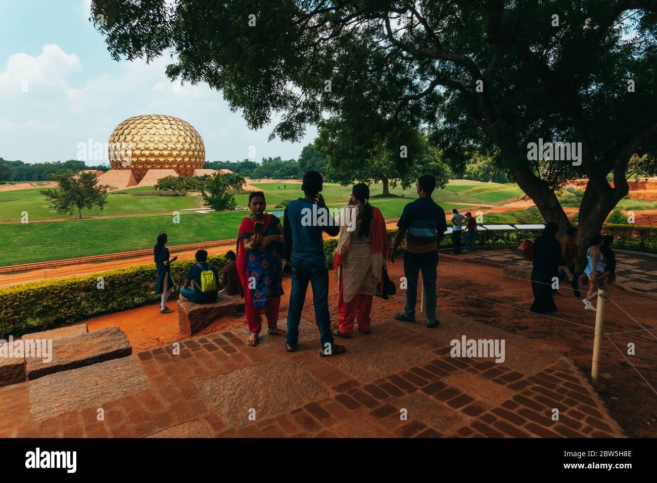 Indische Touristen vor Matrimandir, einer goldenen Kugelstruktur, die für die Meditation in der experimentellen Township Auroville, Indien, gebaut wurde Stockfoto
