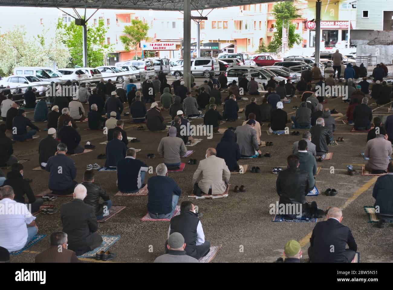 Ankara/Türkei - 29/05/2020 Ankara/Türkei - 29/05/2020: Imam führt die sozial distanzierte Gruppe von muslimen an, die am ersten Freitag auf dem Gebetsruckteppich sitzen Stockfoto