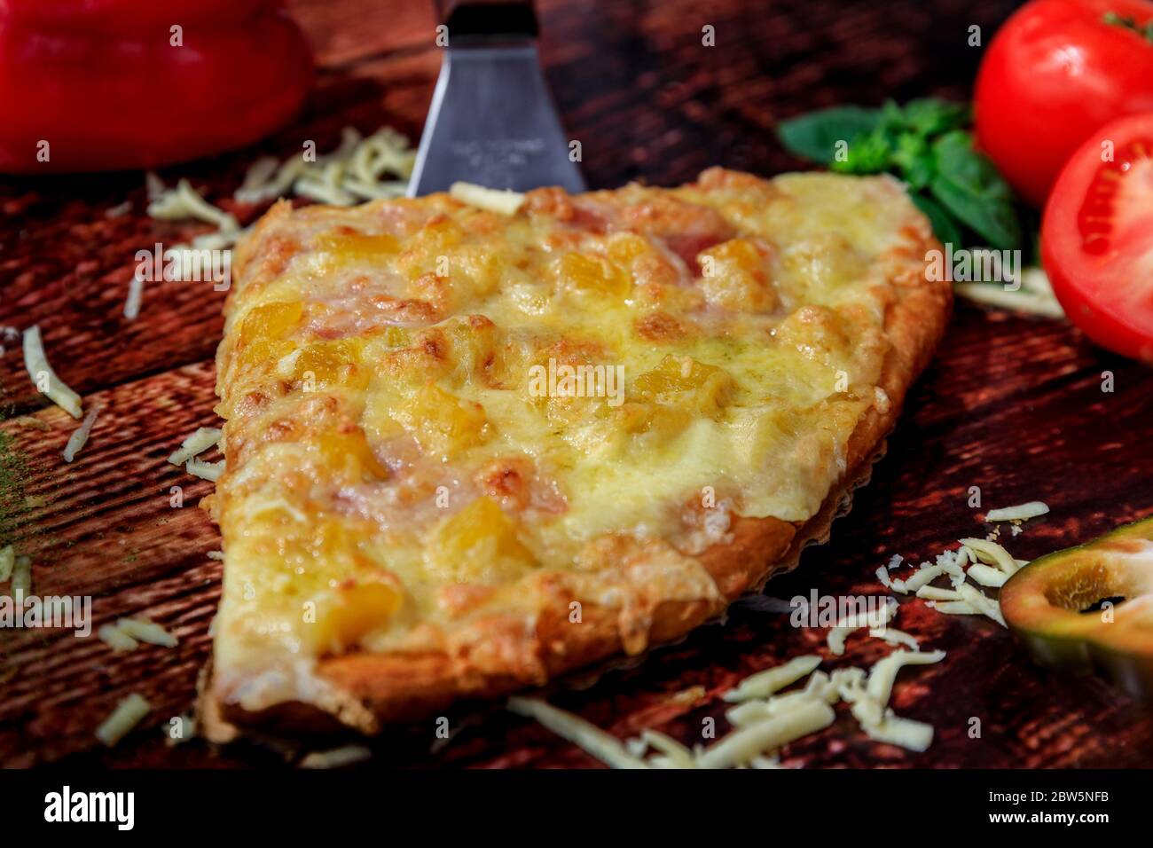 Hawaiianische hausgemachte Pizzabocken mit frischen Zutaten auf einem traditionellen dunklen Holztisch Stockfoto