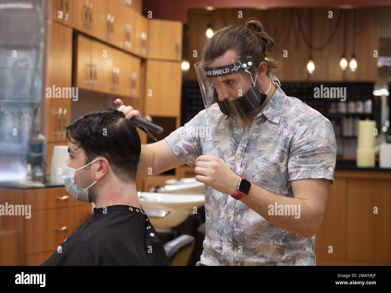 Washington, Unbunden Staaten. Mai 2020. Ein Stylist mit einem schützenden Gesichtsschutz schneidet einem Kunden die Haare im Salon Illusion of Shirlington, als er nach einer COVID-19-Bestellung zum Aufenthalt zu Hause in Shirlington, Virginia am Freitag, den 29. Mai 2020, wieder eröffnet wird. Die Metropolregion DC beginnt, wieder zu öffnen, da viele Geschäfte, Restaurants und Salons seit Mitte März geschlossen sind, um die Verbreitung von COVID-19 zu stoppen. Foto von Kevin Dietsch/UPI Quelle: UPI/Alamy Live News Stockfoto