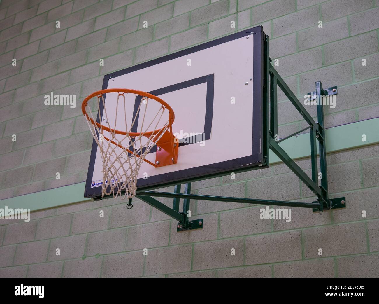Basketballnetz und Brett gegen eine graue und grüne Backsteinwand Stockfoto