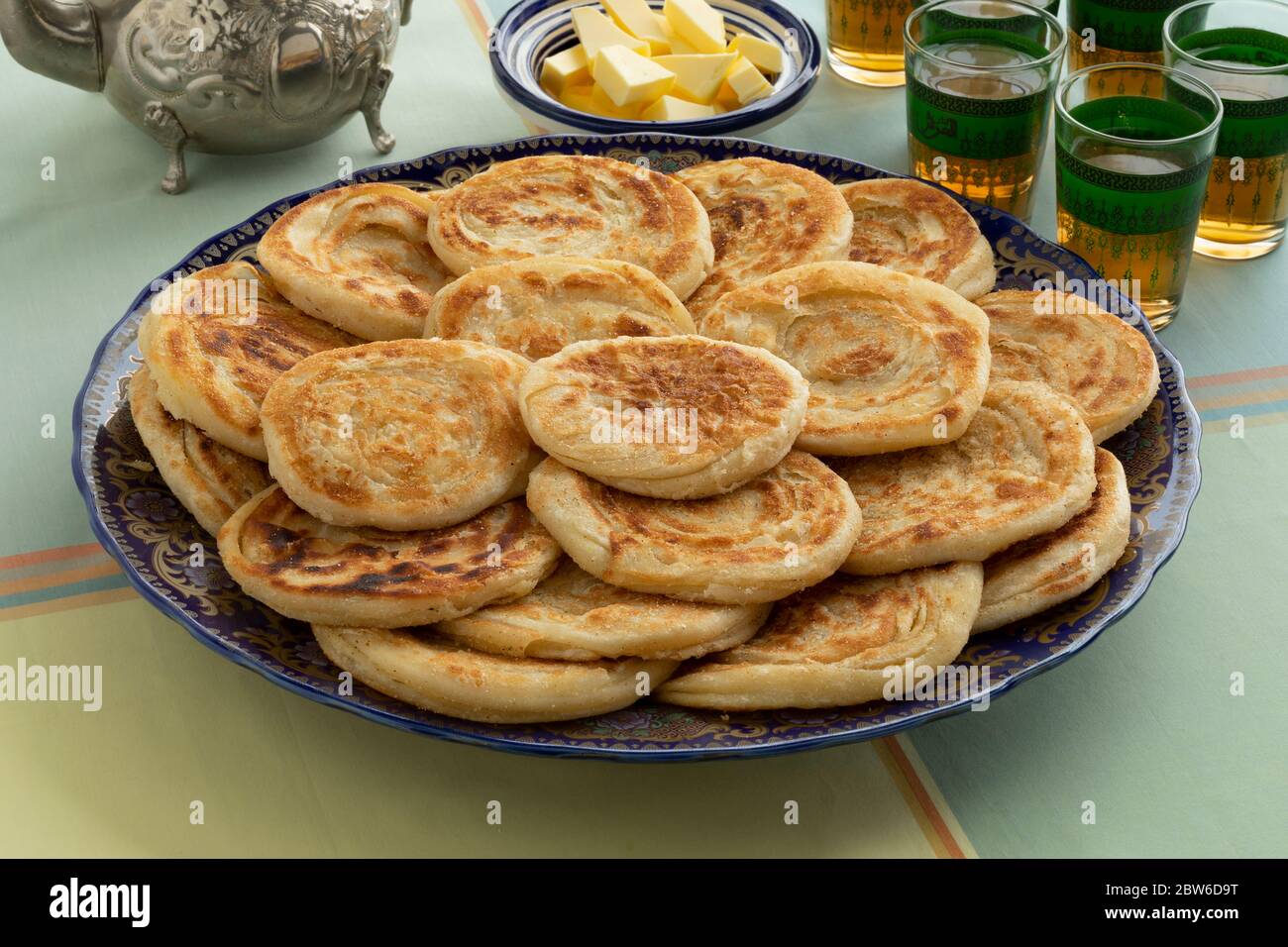 Homemage frisch gebackene Meloui, marokkanische Pfannkuchen auf einem Teller mit Butter und Tee für Eid al-Fitr Stockfoto