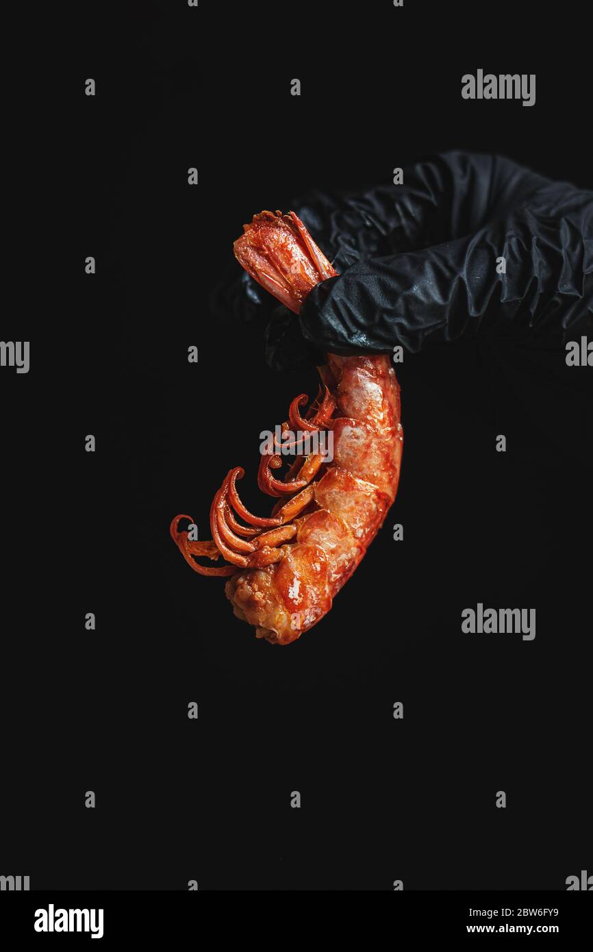 Crop Chef mit gegrillten Garnelen auf schwarz Stockfoto