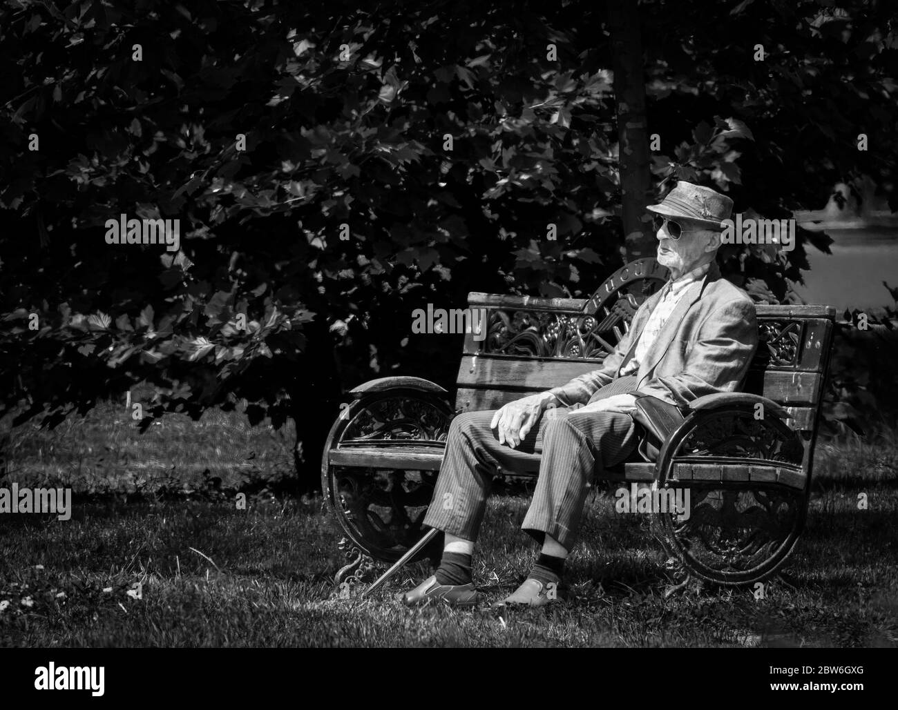 Bukarest/Rumänien - 05.21.2020: Einsamer alter Mann auf einer Bank im Herestrau Park, Bukarest. Senior auf einer Bank ausruhen. Stockfoto