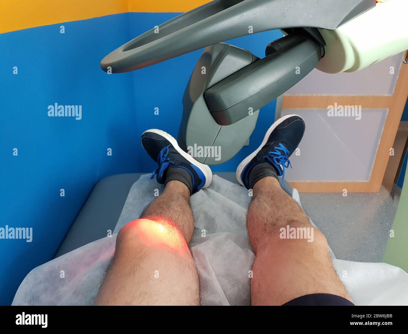 Physikalische Therapie mit einem Laser zur Behandlung eines verletzten Knies Stockfoto