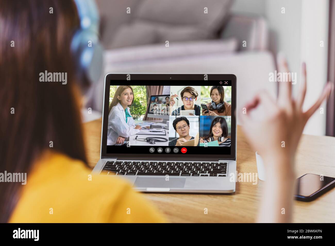 Rückansicht der asiatischen Geschäftsfrau, die mit Arzt und Teamkollegen diskutiert, um Krankheit in Videokonferenz zu verfolgen, wenn Coronavirus Ausbruch, C Stockfoto