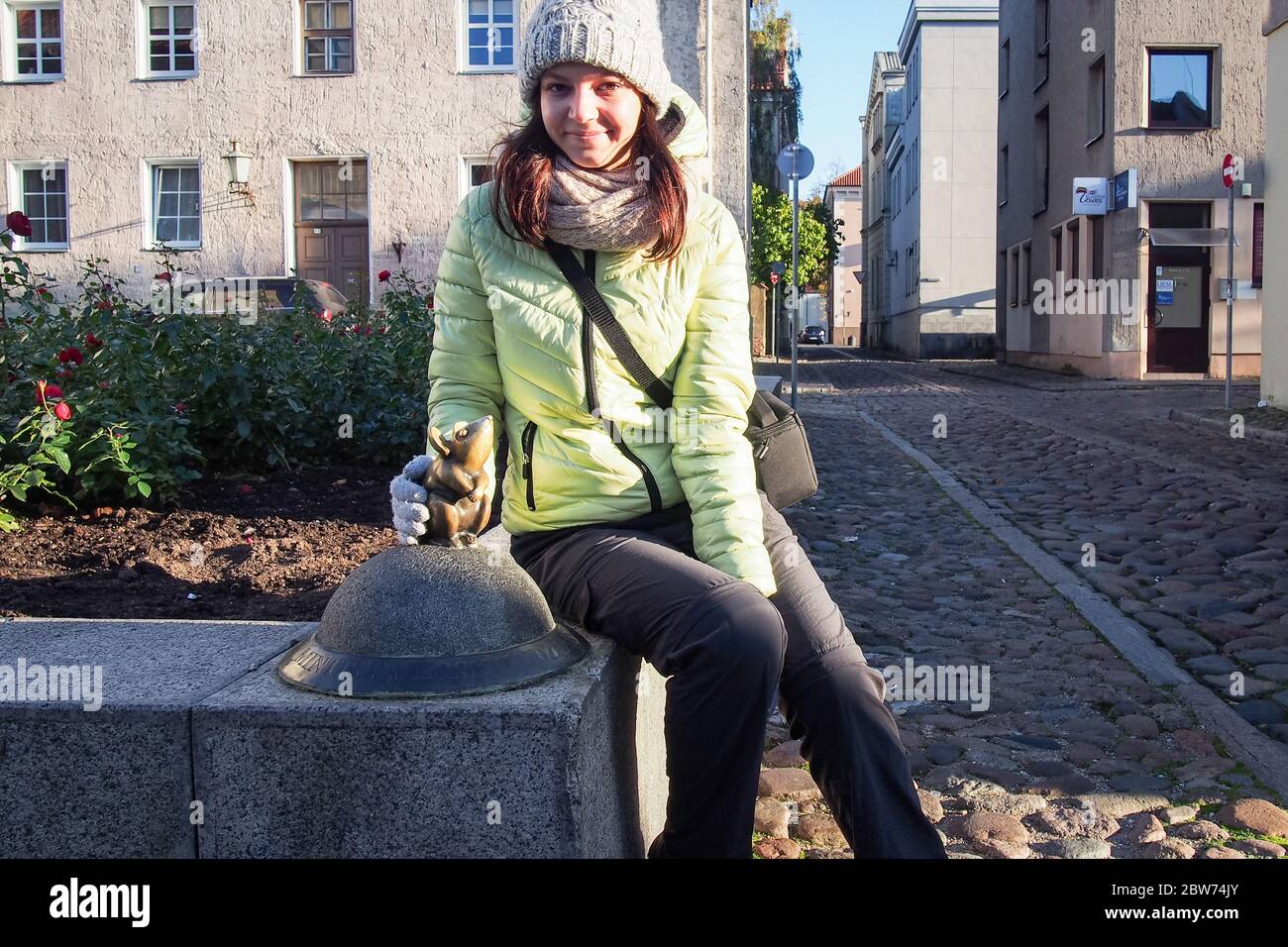 KLAIPEDA, LITAUEN - 15. OKTOBER 2019: Touristenmädchen mit der Bronzeskulptur "Steinlingas peliukas" (wunderbare kleine Maus) Stockfoto