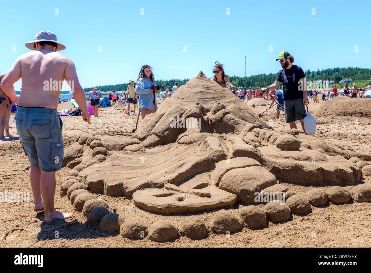 New River Beach, New Brunswick, Kanada - 7. Juli 2018: Der jährliche Wettbewerb für Sandskulpturen. Die Menschen setzen den letzten Schliff auf eine Sandskulptur. Stockfoto