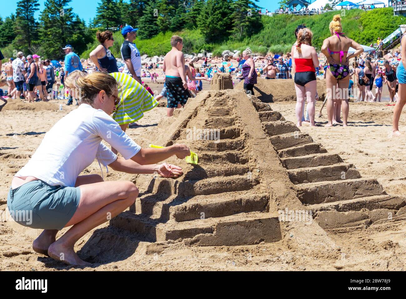 New River Beach, New Brunswick, Kanada - 7. Juli 2018: Der jährliche Wettbewerb für Sandskulpturen. Eine Frau arbeitet an einer Skulptur einer aztekischen Pyramide. Stockfoto