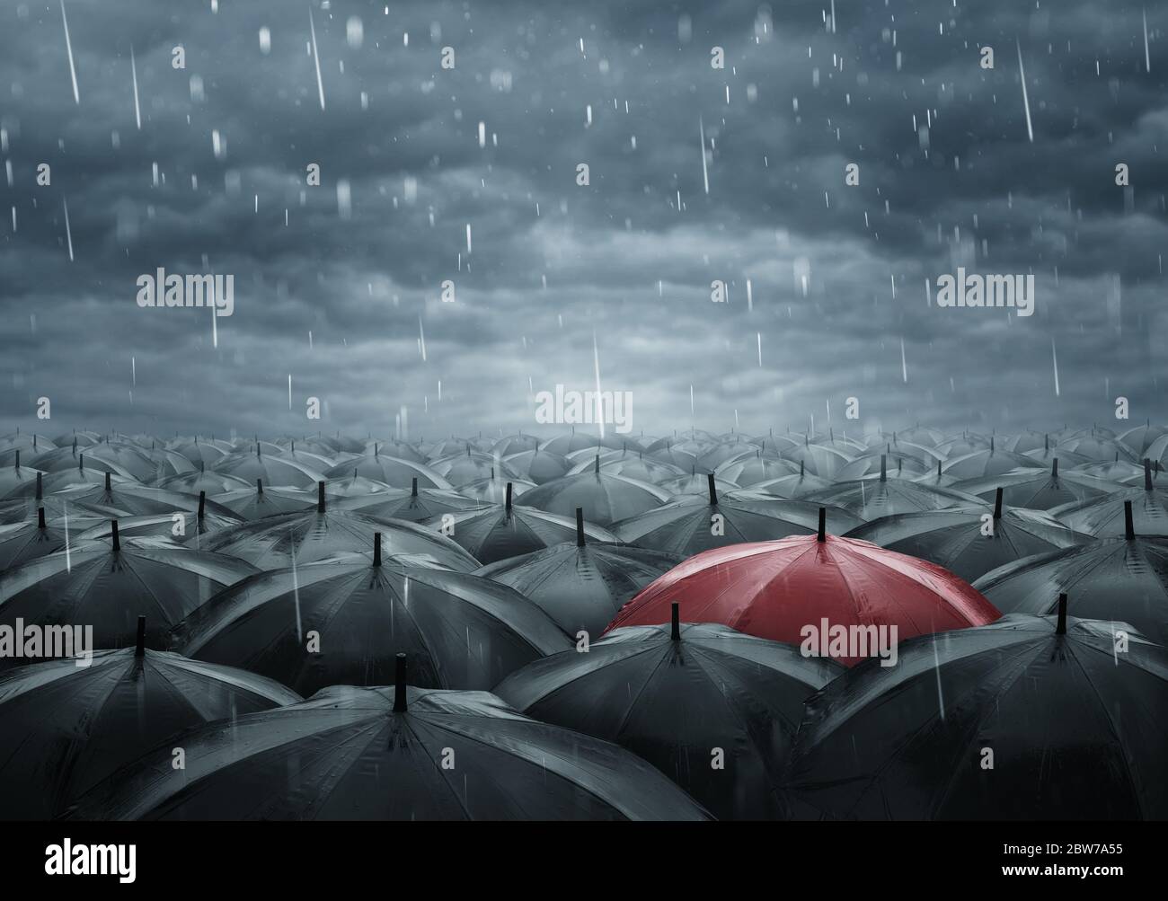Aus dem Crowd-Konzept heraus, einzelner roter Schirm zwischen vielen schwarzen an einem Raint-Tag Stockfoto