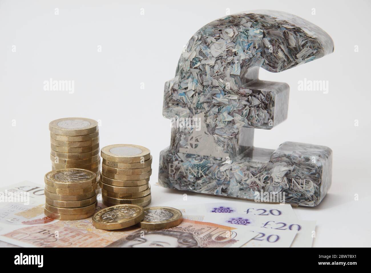 Britisches Pfund Papiergewicht aus gehackten £5 Noten neben £1 Münzen und Noten UK Stockfoto