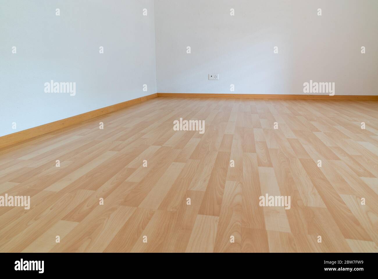 Ein niedriger Winkel horizontale Ansicht des neuen Holzparkettbodens in einem hellen Licht und weißen Apartment-Zimmer Stockfoto