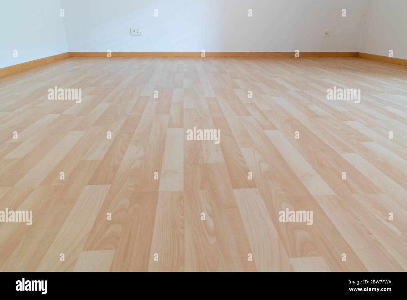 Ein niedriger Winkel horizontale Ansicht des neuen Holzparkettbodens in einem hellen Licht und weißen Apartment-Zimmer Stockfoto