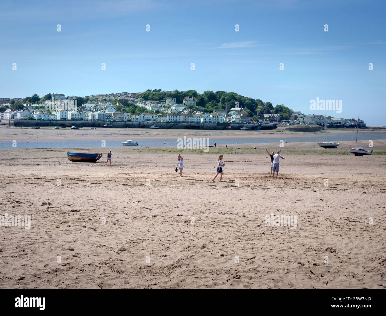 INSTOW, DEVON, UK - MAI 24 2020: Kleine Familiengruppen nutzen die Gelegenheit für Bewegung, frische Luft und Spaß am Sandstrand während der COVID-Sperrung Stockfoto