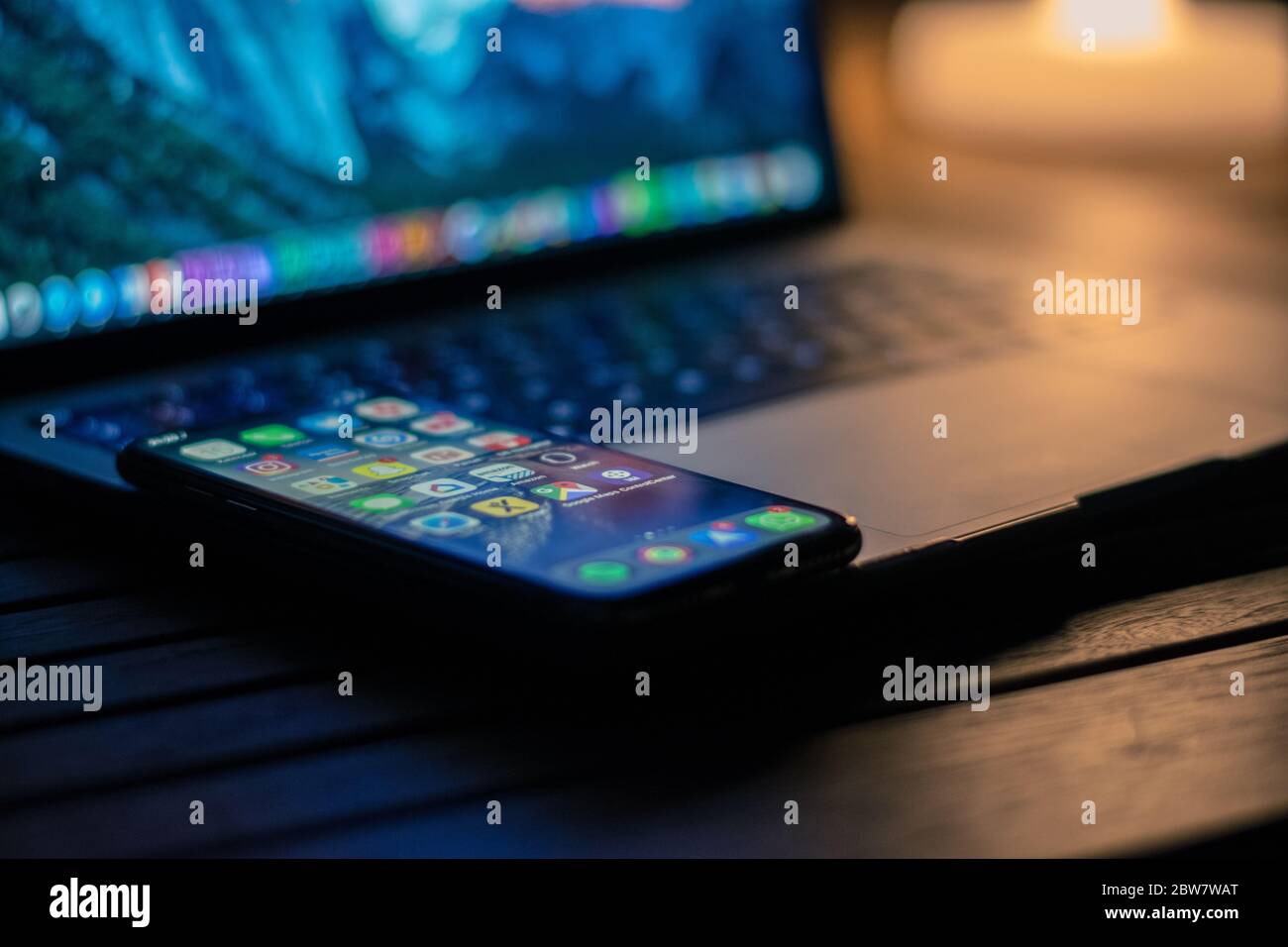 IPhone auf einem MacBook Pro aufklappen in der Dämmerung Stockfoto