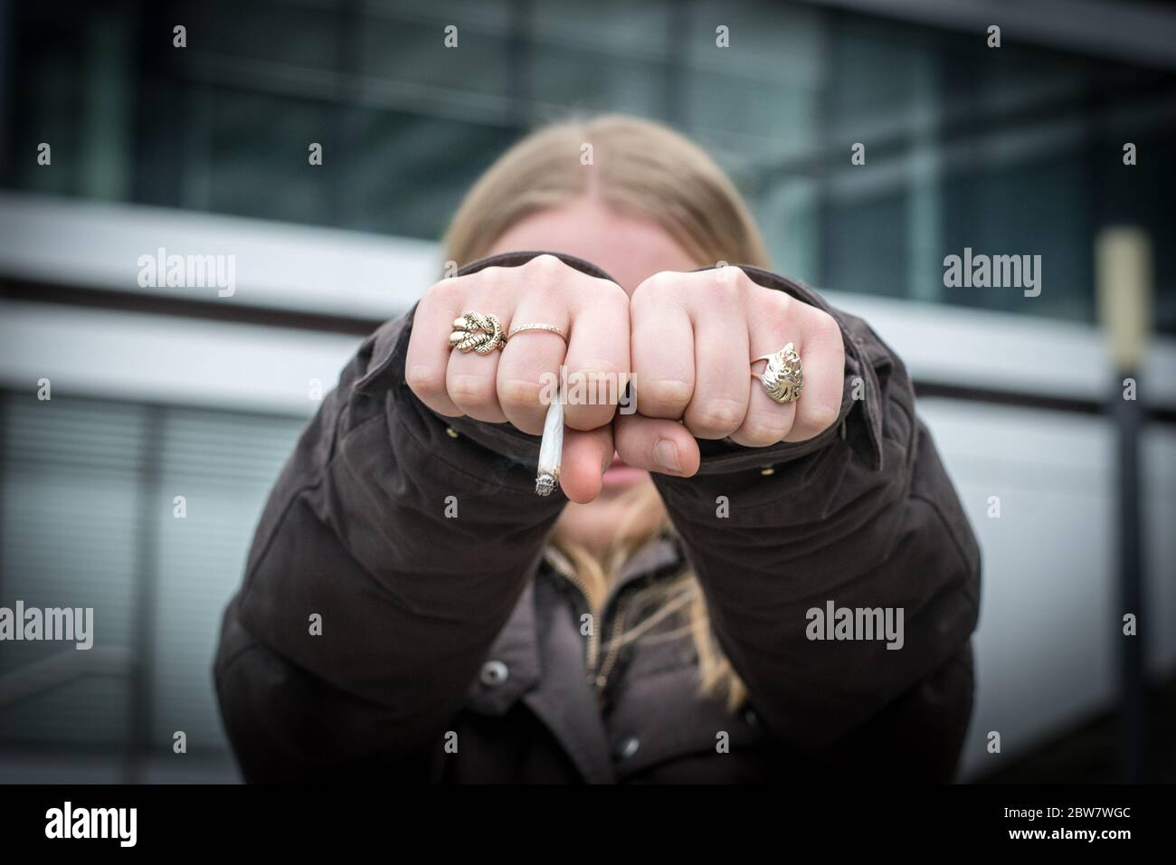 Jugendliche zeigt Füste mit Zigarette Stockfoto