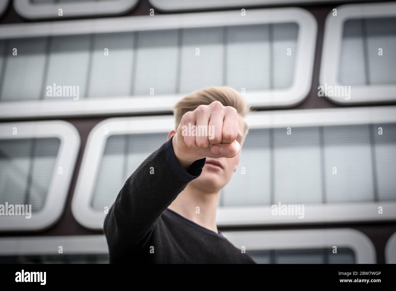 Jugendlicher schlägt mit Faust zu - Gewaltdarstellung Stockfoto