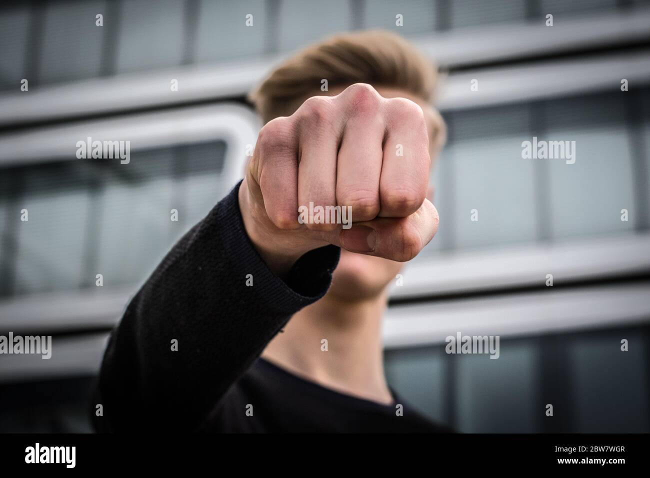 Jugendlicher schlägt mit Faust zu - Gewaltdarstellung Stockfoto