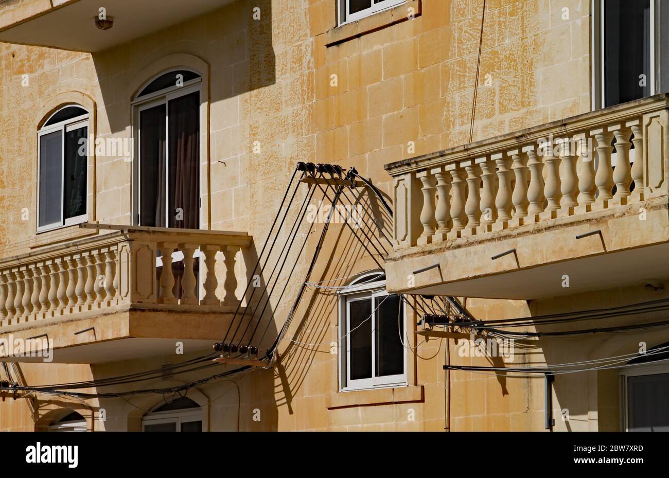 VALLETTA, MALTA - 15. NOVEMBER 2019:Nahaufnahme von zwei Balkonen mit Steinbalustraden auf einem maltesischen Wohnblock mit der außenstromzust Stockfoto