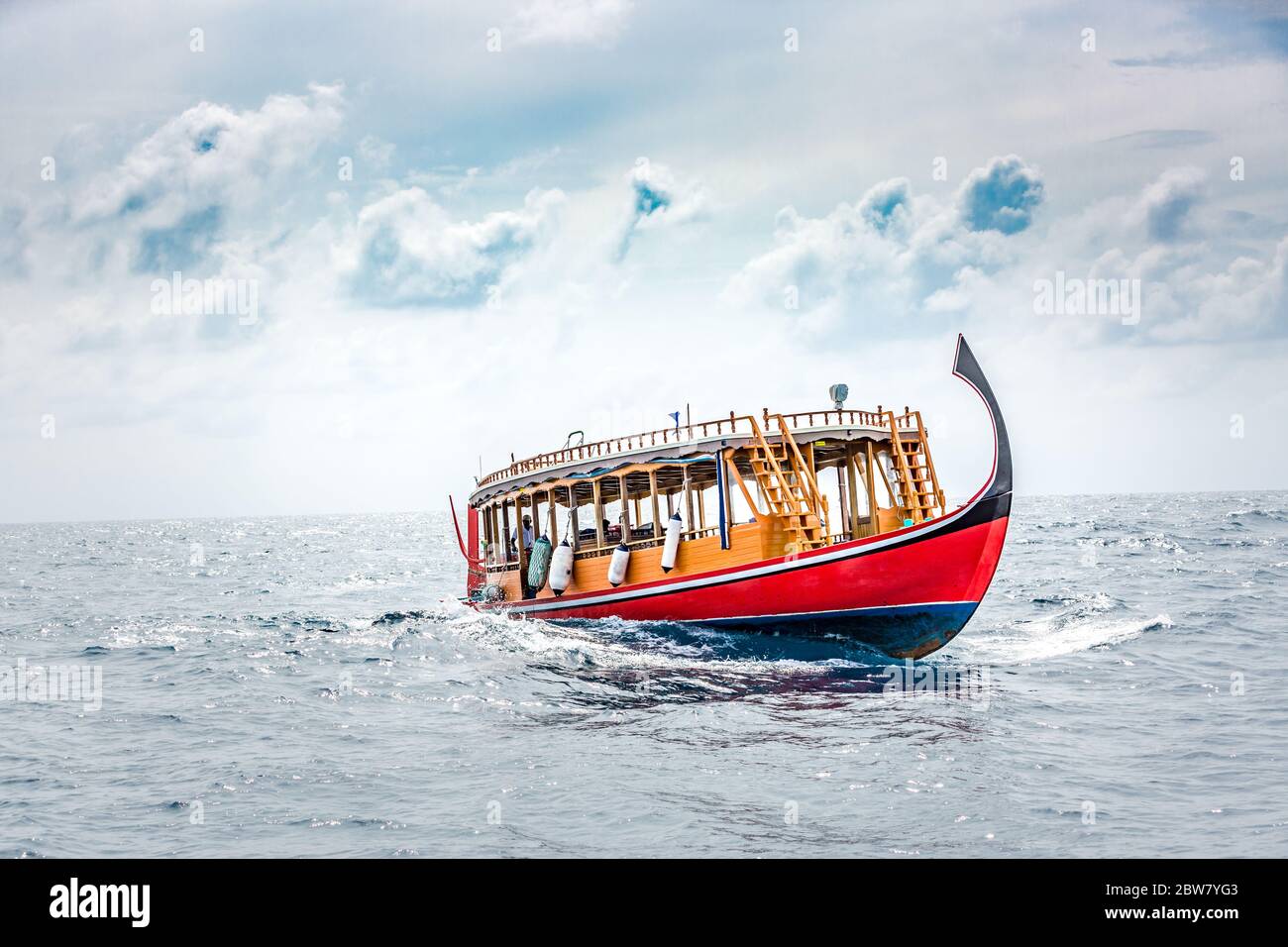Wunderbares maledivisches Boot Dhoni auf tropischem blauem Meer, mit Touristen zum Schnorcheln und Tauchen, um die Unterwasserwelt zu sehen Stockfoto