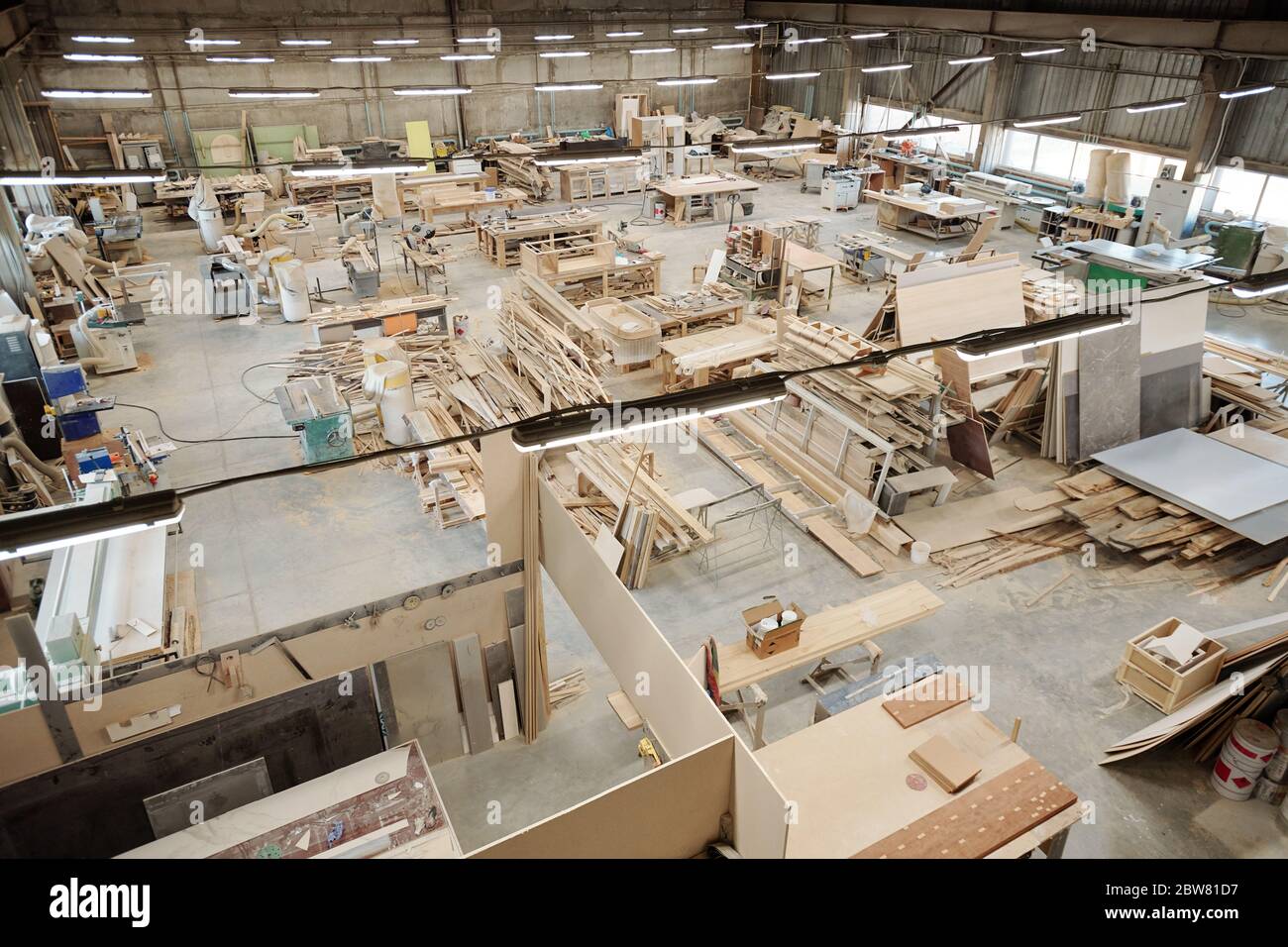 Das Innere der großen Werkstatt der zeitgenössischen Möbelfabrik mit Arbeitsplätzen, die aus Werkbänken mit Arbeitsmaterialien bestehen Stockfoto