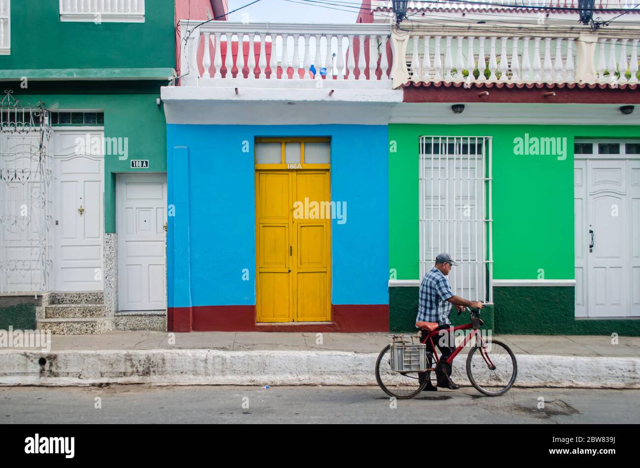 Ein Mann, der mit dem Fahrrad durch die Straßen von Trinidad in Kuba fährt Stockfoto
