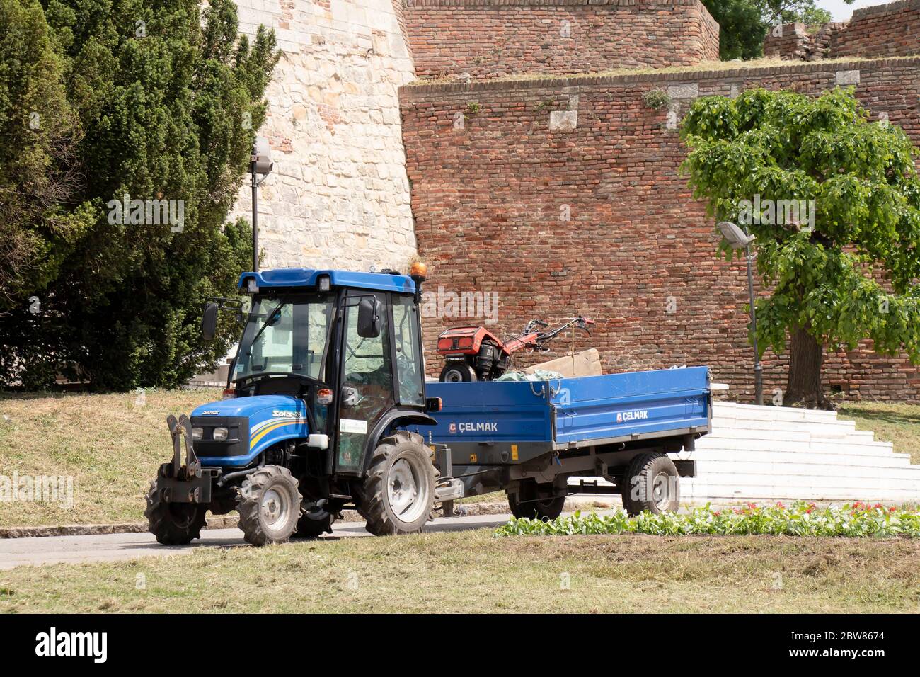 Belgrad, Serbien - 21. Mai 2020: Stadt Grün Service Traktor Fahrzeug mit einem Rasenmäher in seinem Anhänger, in Kalemegdan Stadtpark und Festung Stockfoto