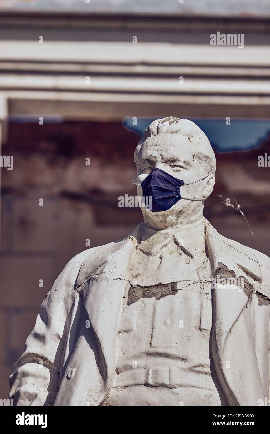 Astrachan / Russland - 29. Mai 2020: Denkmal für einen der bolschewistischen revolutionäre Kirow in einer medizinischen Maske. Park in der Stadt Astrachan, Russland. Hochwertige Fotos Stockfoto