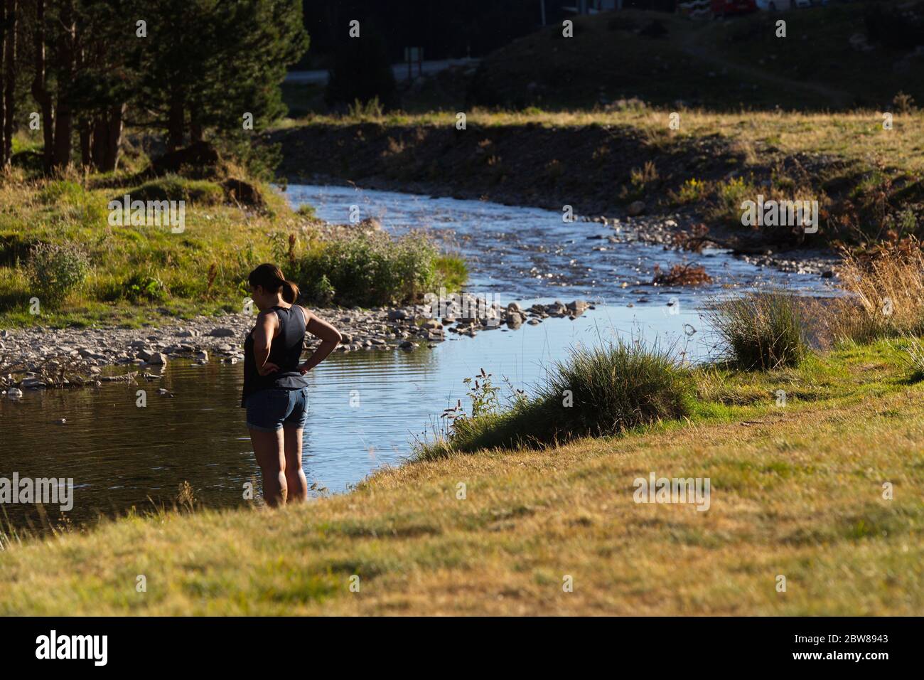 Llanos del Hospital, Huesca/Spanien; 21. August 2017. Eine Frau entspannt sich am Fluss. Ort namens Llanos del Hospital gehört zur Gemeinde Bena Stockfoto