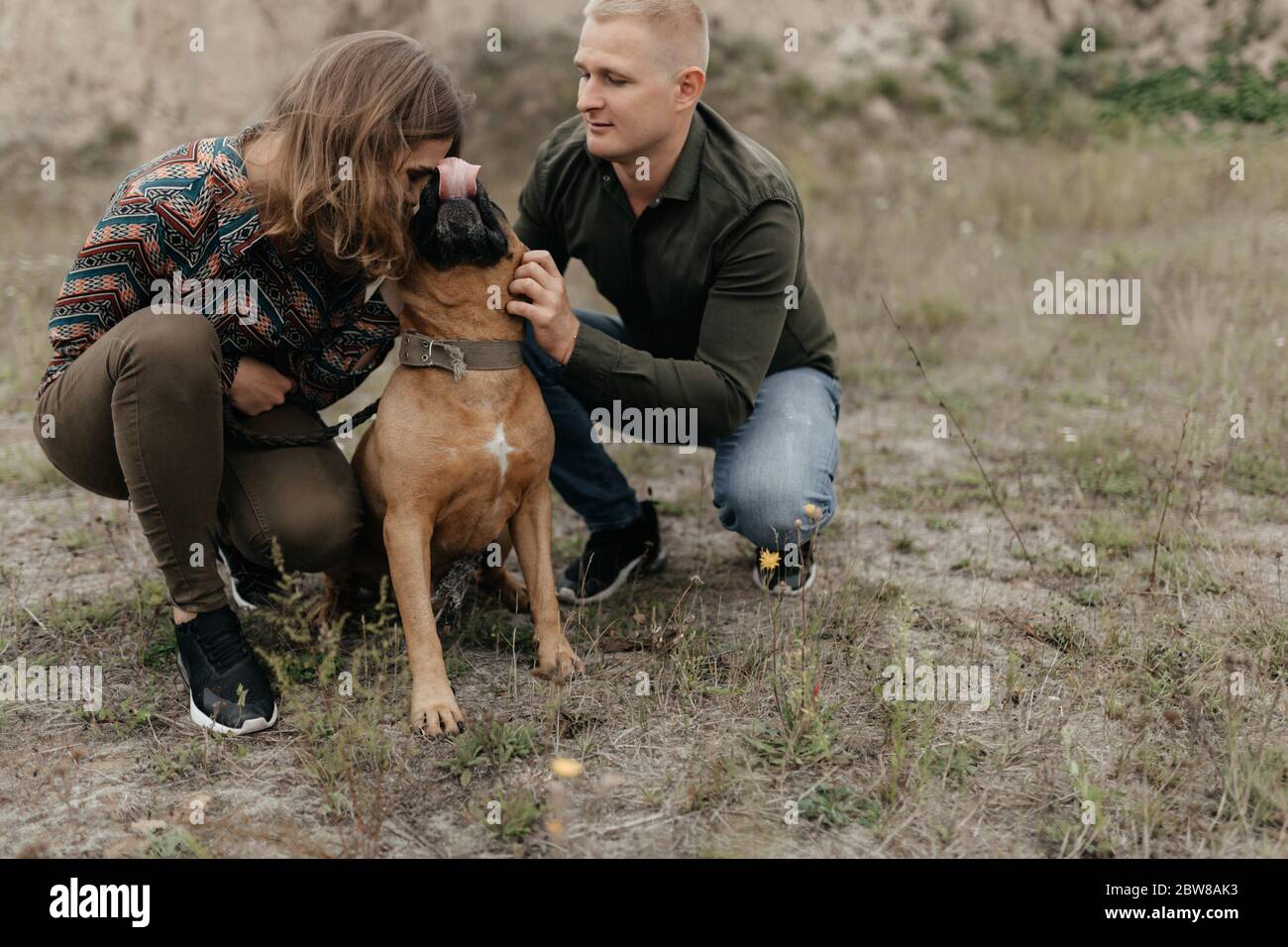 Ein Paar in der Liebe streicheln ihren Hund in der Natur Stockfoto