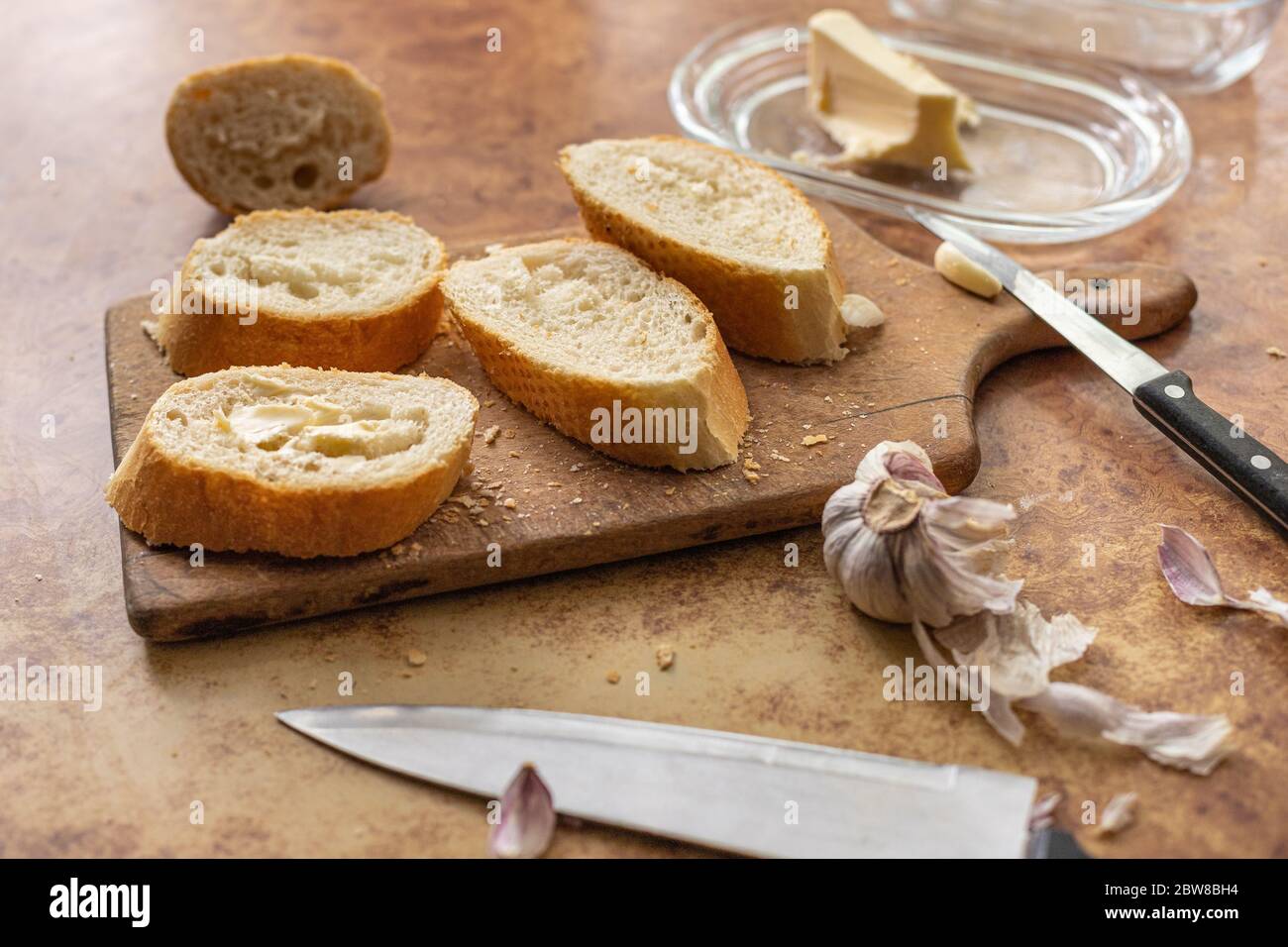 Baguette mit Butter und Knoblauch. Rustikales Frühstück. Landhaus. Stockfoto