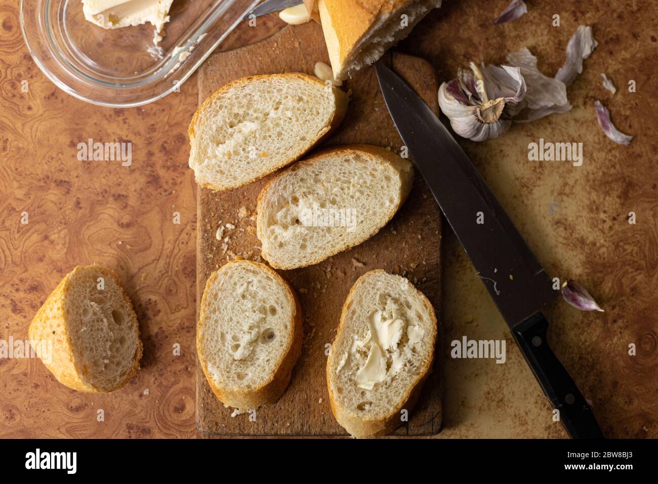 Baguette mit Butter und Knoblauch. Rustikales Frühstück. Landhaus. Stockfoto