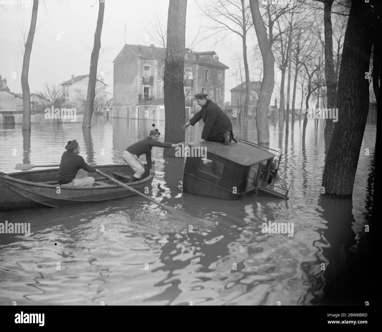 Paris und seine Vororte unter Wasser. Französische Marineinfanteristen aus Brest retten die Insassen eines Autos zwischen Alfortville und Choisy le ROI . Januar 1924 Stockfoto