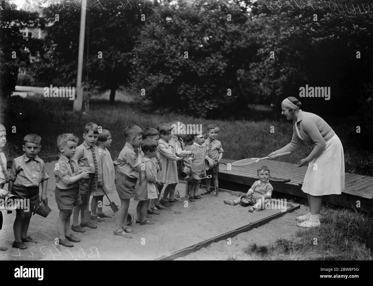 Berühmte Tennis-Stars helfen Wohltätigkeit. Miss Betty Nuthalle genießt ein Spiel mit einigen der Waisen, bevor sie ihre Ausstellung auf dem Gelände des Royal Waisenhaus, Wanstead, in Hilfe der Evelyn Colyer Gedenkfonds. 17 Juni 1932 Stockfoto