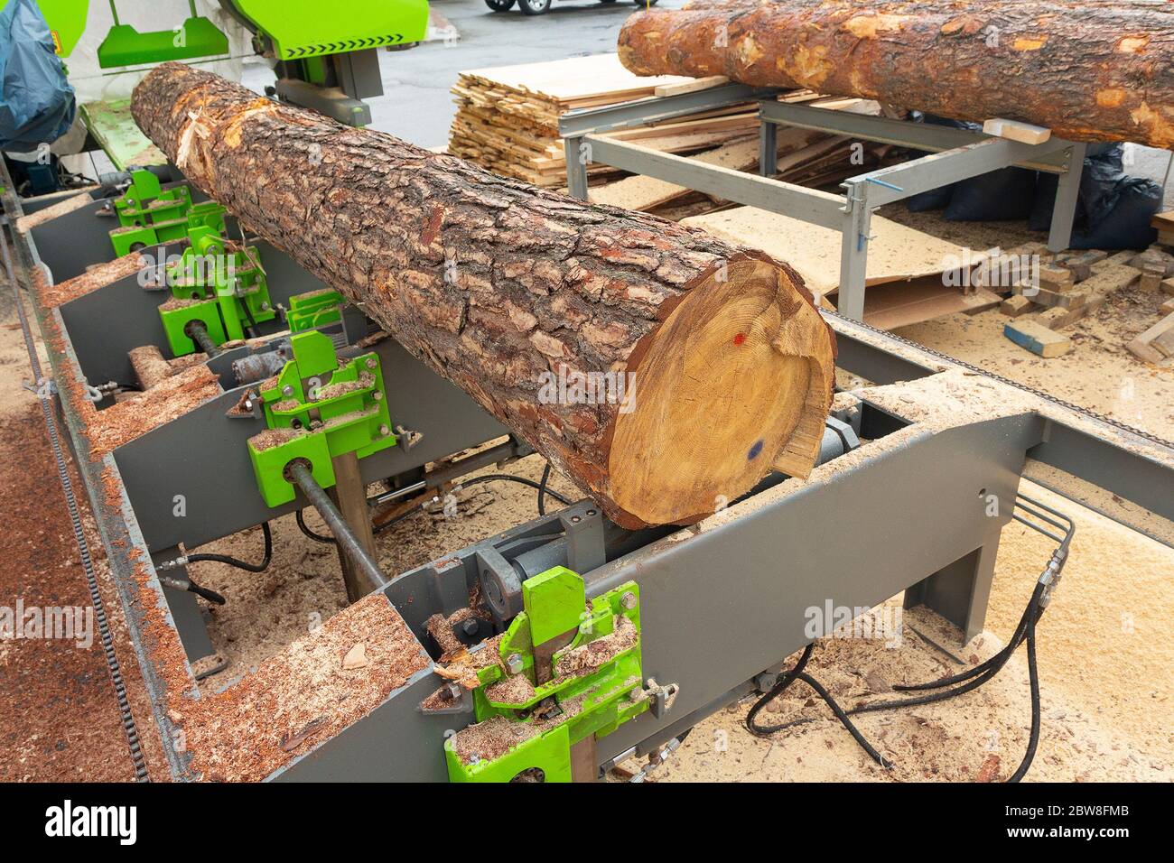 In einem modernen Sägewerk wird ein großer Baumspeicher automatisch schnell und präzise geschnitten. Branche Stockfoto