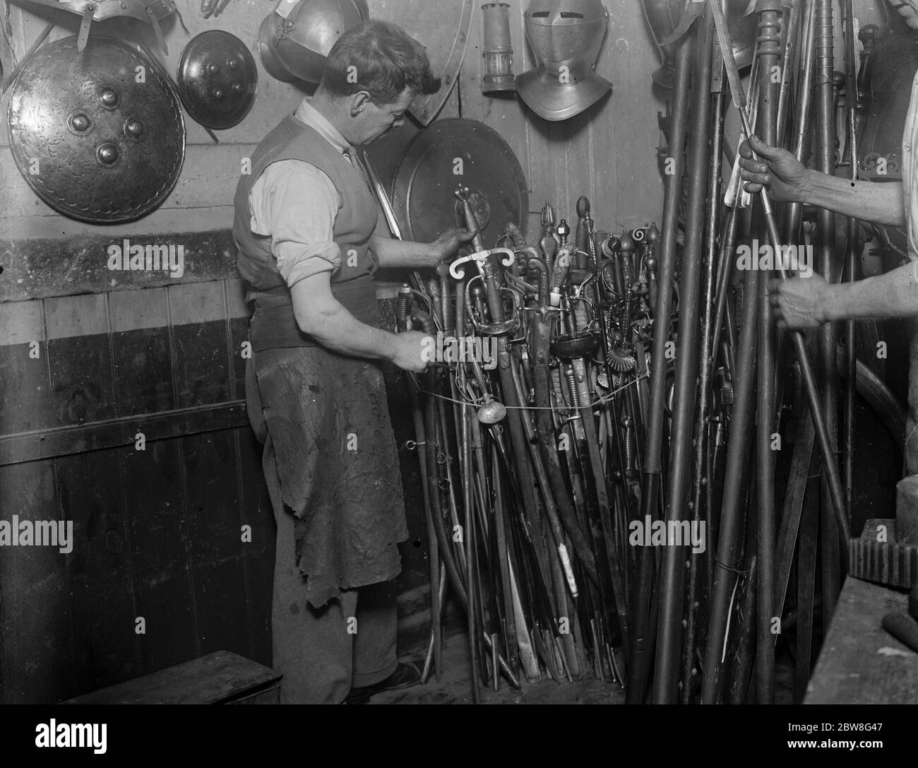 Die letzte einer langen Reihe von Rüstern . Herr Sam Rex sortiert einige von 9,000 modernen und antiken Schwertern. 26. September 1930 Stockfoto