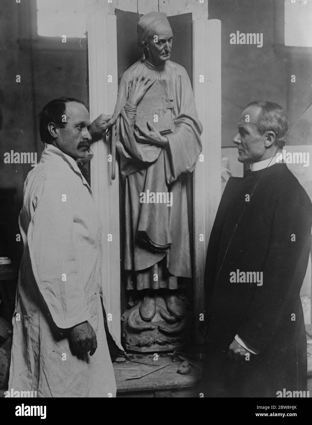 Londoner Bildhauer bei der Arbeit in der New York Cathedral . Herr John Angel , der bekannte Londoner Bildhauer, Wer wurde in die USA von Herrn Ralph Adams Oram eingeladen, Architekt von St. John the Divine, New York, um Figur für die Dekoration der Taufkapelle der Kathedrale zu tun, bei der Arbeit mit einem Lehmmodell von Thomas a Kempis. Bischof Manning ist rechts. 16. Januar 1926 Stockfoto