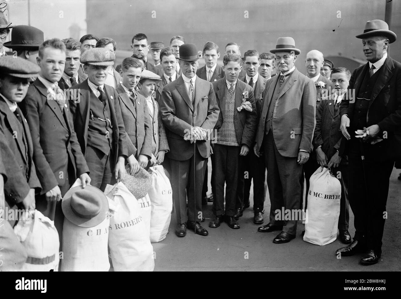 Viscount Jellicoe sieht Matrosen Söhne aus nach Neuseeland. Viscount Jellicoe (Melone Hut) und Sir James Allen, Hochkommissar für Neuseeland, mit den Jungen. 16 Juli 1925 Stockfoto