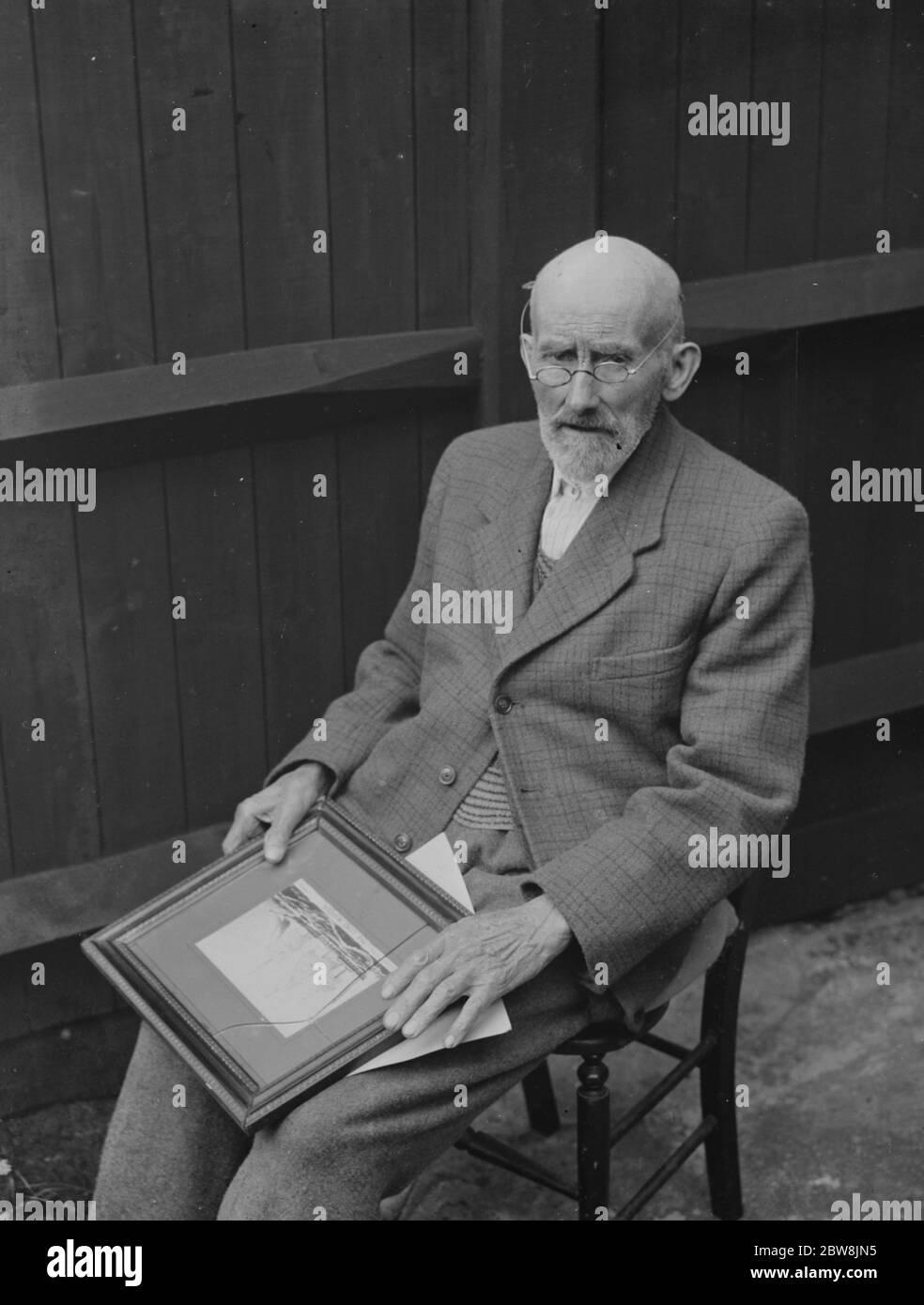 Crayford alter Mann sitzt mit einem Bild. 1935 . Stockfoto