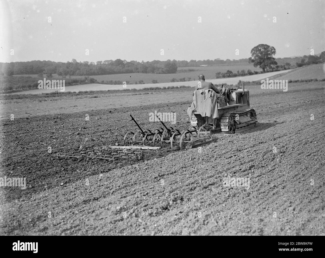 Ein Bauer und sein Panzergleisentraktor bewirtschaftet ein Feld. 1935 . Stockfoto