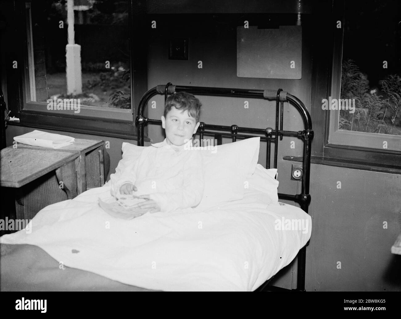Jetzt in seinem Krankenhausbett, JW Davies, auf der elektrischen Leitung in Barnehurst gefunden. 1935 . Stockfoto