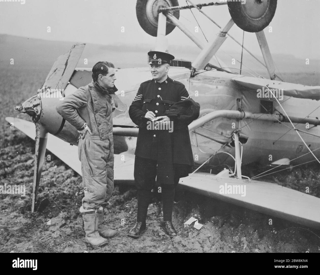 Mr. JF Carrols RAF spricht mit einem Polizisten neben seinem , Hawker Hart auf den Kopf gestellt, nachdem er bei der Landung in Farningham übergegangen ist . 1938 Stockfoto